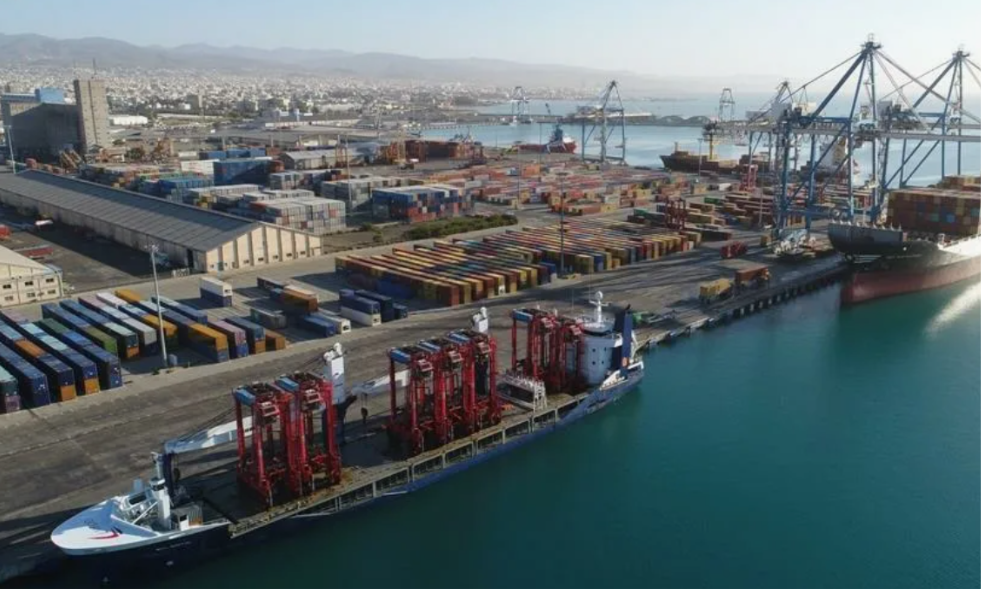 Cargo vessels alongside a container terminal with cranes and container stacks